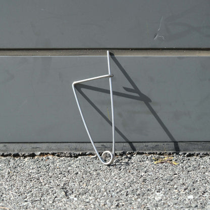 150mm Stainless Steel Crab Bait Clip resting on pavement against a grey surface.