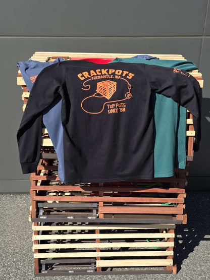 Crackpots Long Sleeve Tee - M displayed on a wooden pallet with bright orange design, showcasing various colors.