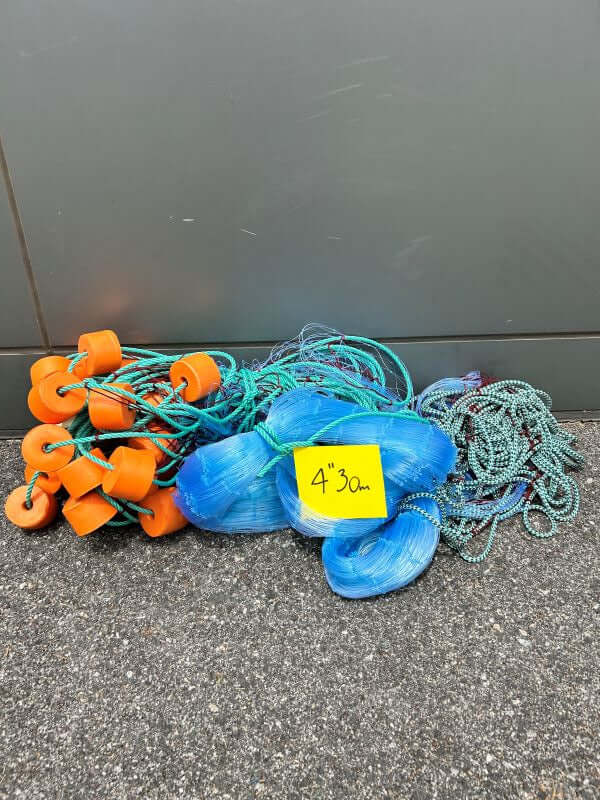GILL NET L14 4" 25MD 30M with floats and lines displayed on a surface, ideal for fishing.
