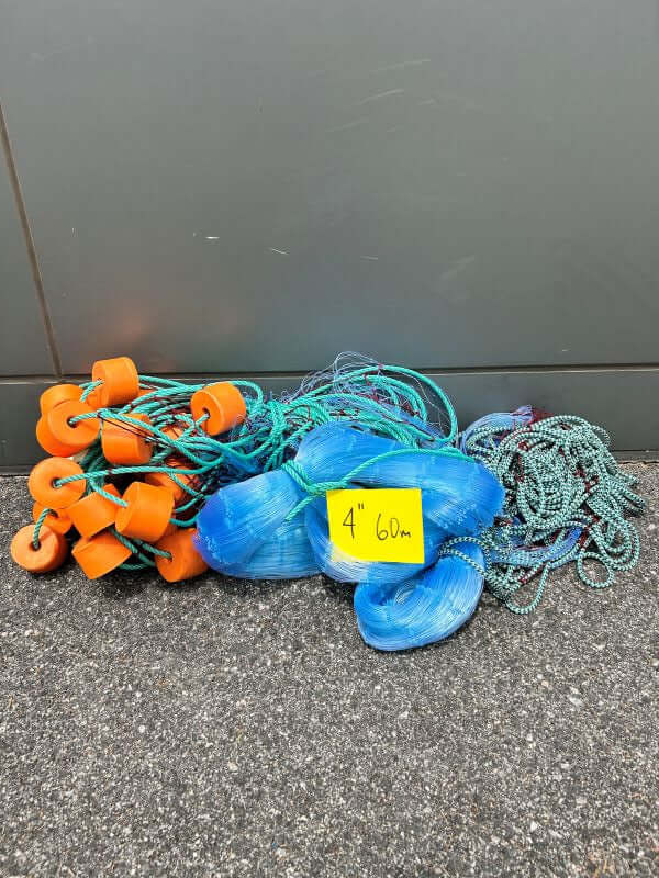GILL NET L14 4" 25MD 60M fishing gear including 4" mesh netting and accessories displayed on pavement.