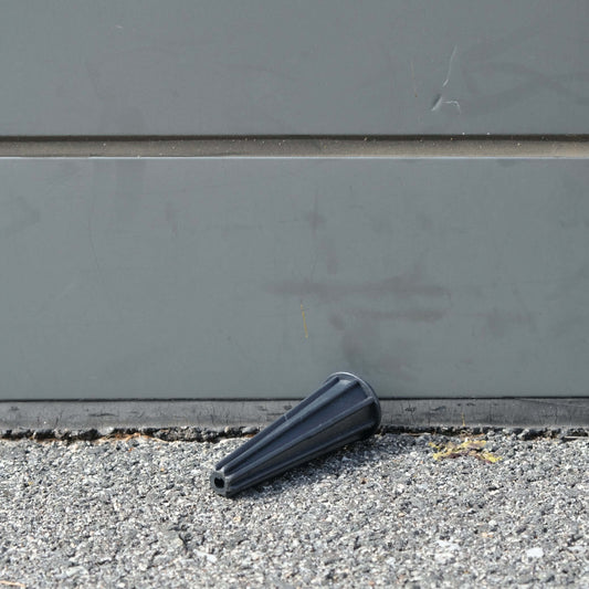 ROPE SMOOTHER resting on pavement near a wall, showing its cone shape and functionality.