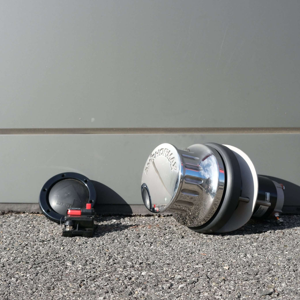 WINCH ANCHORMAX 12V F/S components arranged on a gravel surface with a grey backdrop.