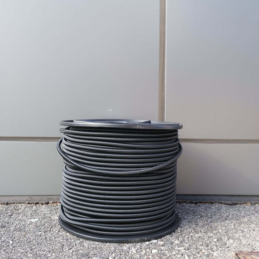 SHOCK CORD 7MM X 100M BLK coil on a spool, ideal for securing and fastening applications.