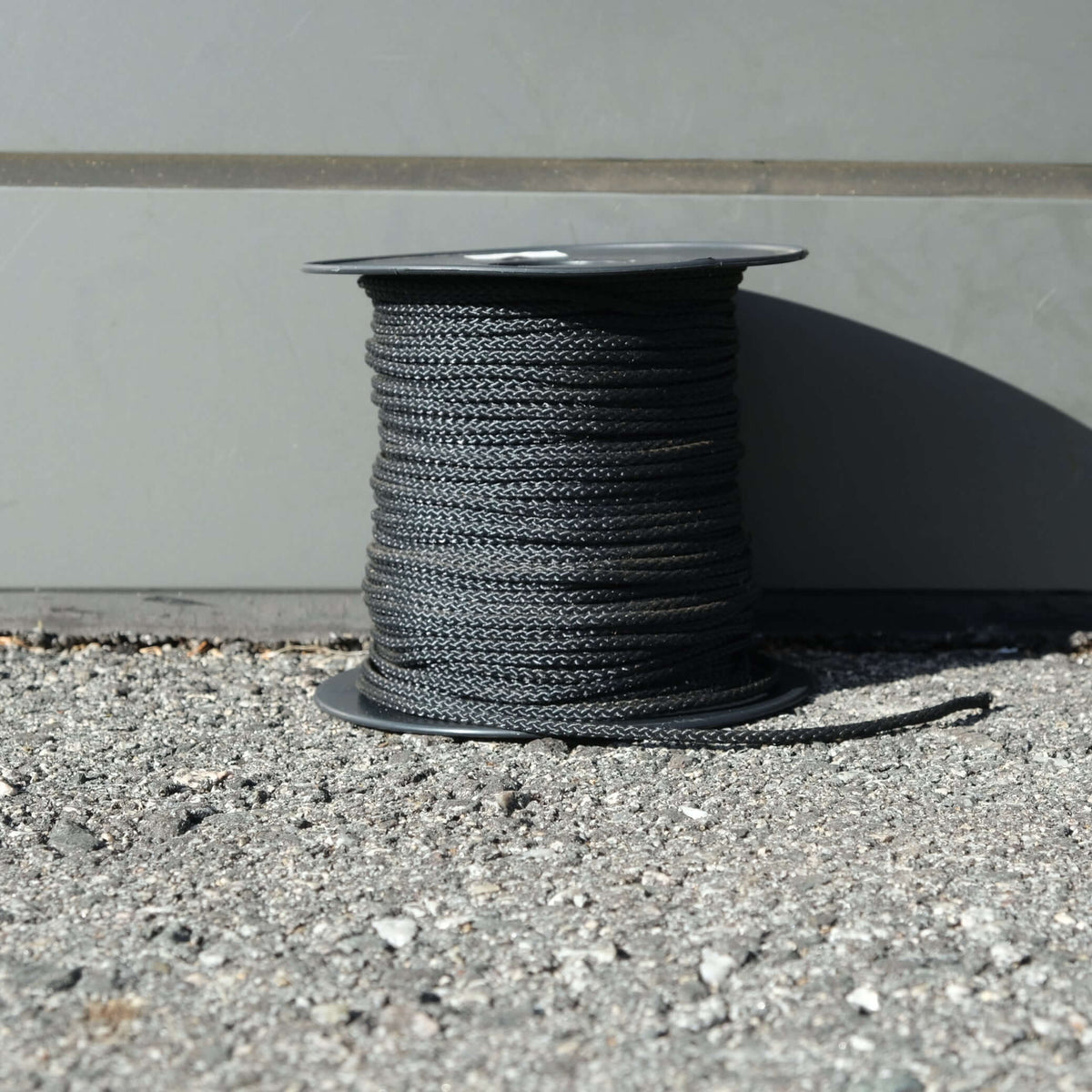 VB CORD 2.5MM X 100M BLACK on a spool, featuring durable UV treated polyester for strong applications.