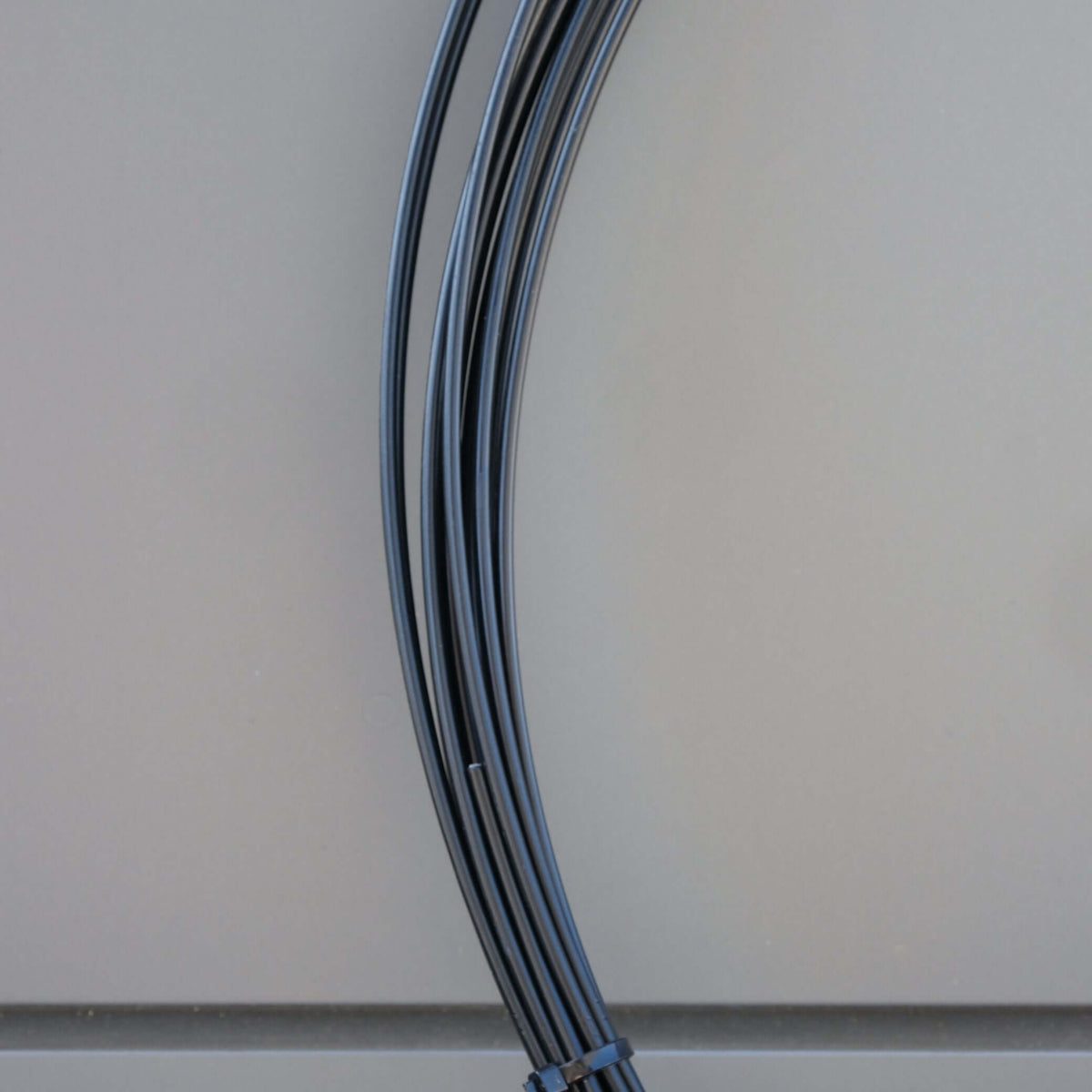 WIRE PVC COATED 3.15MM X M BLK close-up of black PVC coated wire suitable for connecting nets and shade cloth.