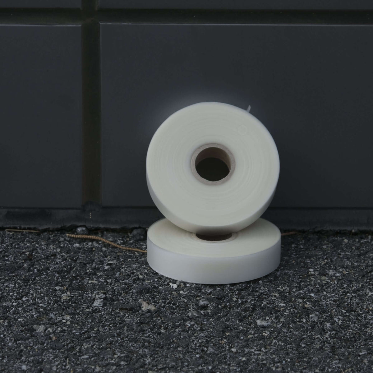 GRAFT TAPE 19MM X 50M displayed on asphalt surface, showcasing soft and translucent grafting tape rolls.